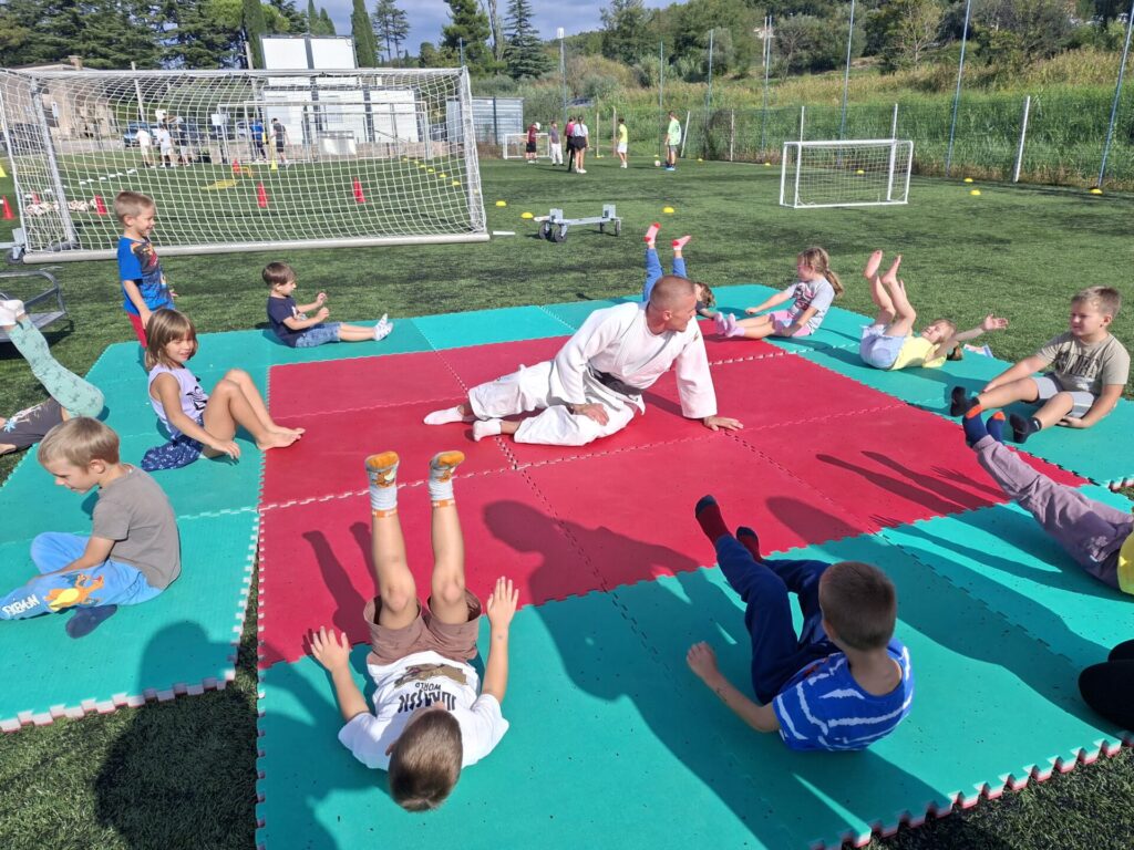 Trener juda na blazinah skupaj z otroki.