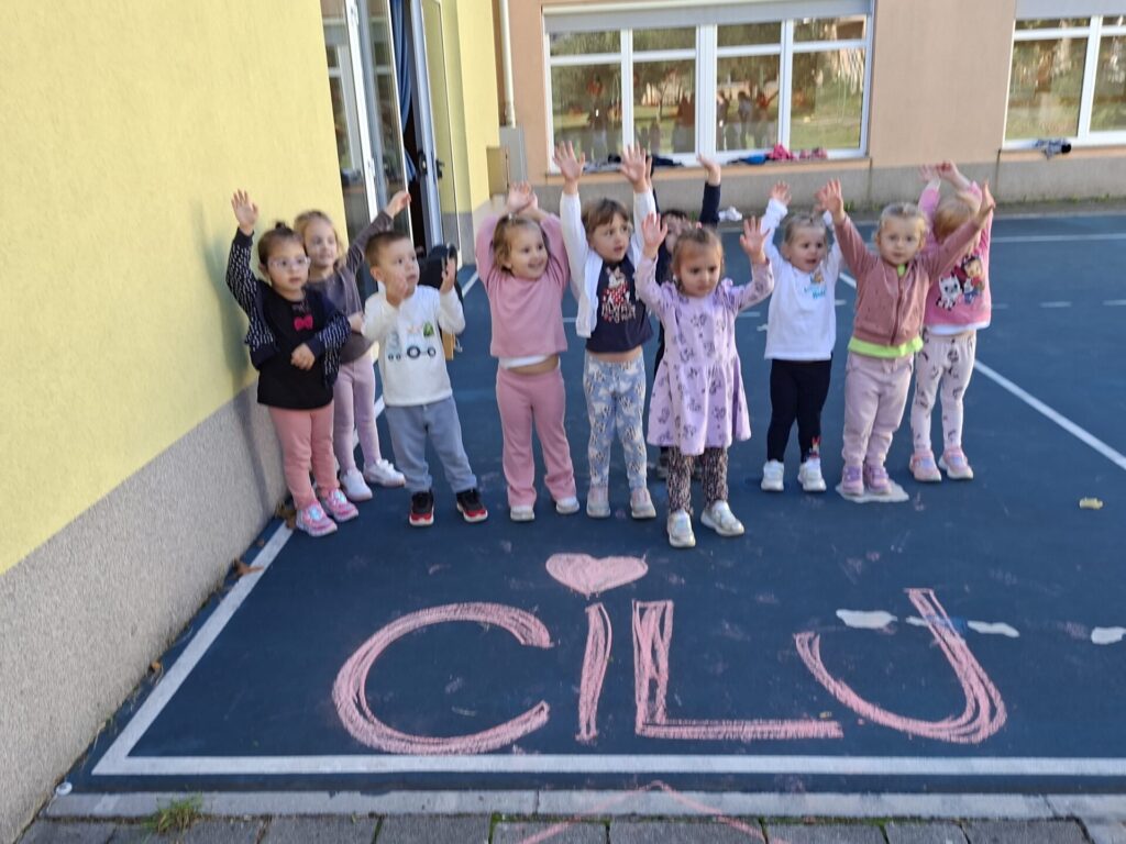 Otroci mahajo na cilju.